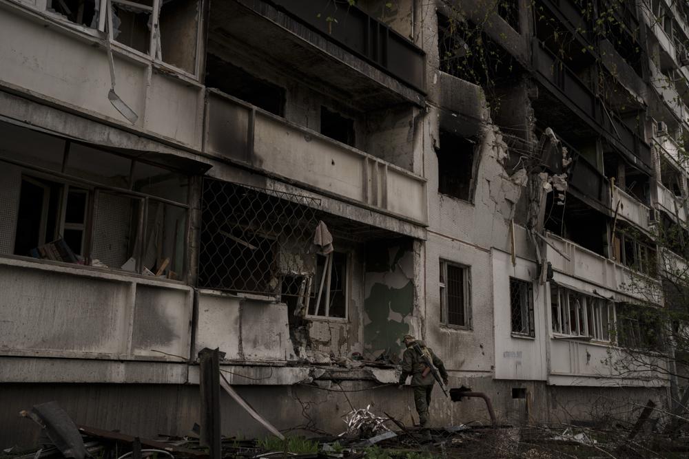 Un militar ucraniano inspecciona un edificio de apartamentos con graves daños tras un bombardeo ruso en Járkiv, Ucrania, el domingo 24 de abril de 2022. (AP Foto/Felipe Dana)