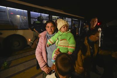 Varias personas evacuadas desde Jersón salen de un bus a su llegada a Dzhankoi, Crimea, el 10 de noviembre de 2022. (AP Foto)