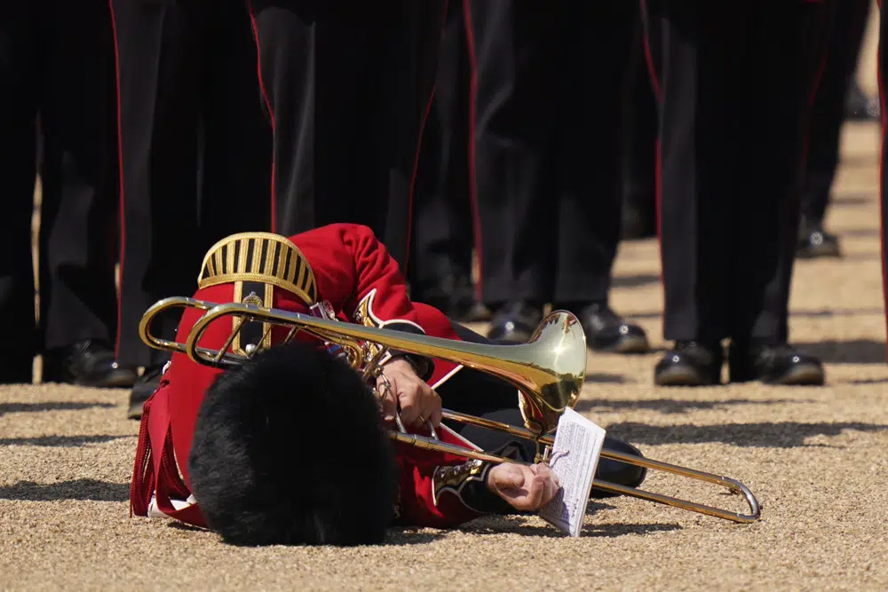 A trombone player of the military band faints during the Colonel's Review, the final rehearsal of the Trooping the Colour, the King's annual birthday parade, at Horse Guards Parade in London, Saturday, June 10, 2023. (AP Photo/Alberto Pezzali)