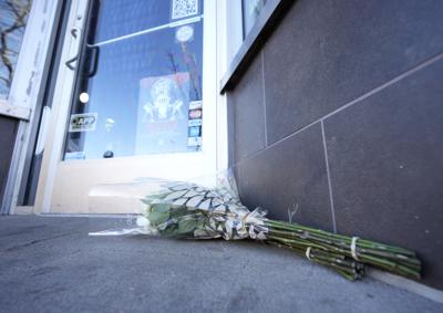 Bouquets of flowers are placed outside the door of a tattoo parlor along South Broadway Tuesday, Dec. 28, 2021 in Denver, one of the scenes of a shooting spree that left five people dead—including the suspected shooter Monday evening—and left a few more people wounded. The spree spread from the core of Denver to the western suburb of Lakewood where the suspect was shot and killed by police near a busy intersection in a bustling shopping district. (AP Photo/David Zalubowski)