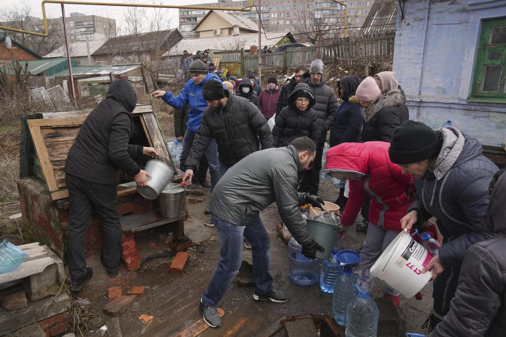 La gente hace fila para sacar agua del pozo en las afueras de Mariupol, Ucrania, el miércoles 9 de marzo de 2022. Un ataque ruso ha dañado gravemente un hospital de maternidad en la ciudad portuaria sitiada de Mariupol, dicen funcionarios ucranianos.  (Foto AP/Evgeniy Maloletka)