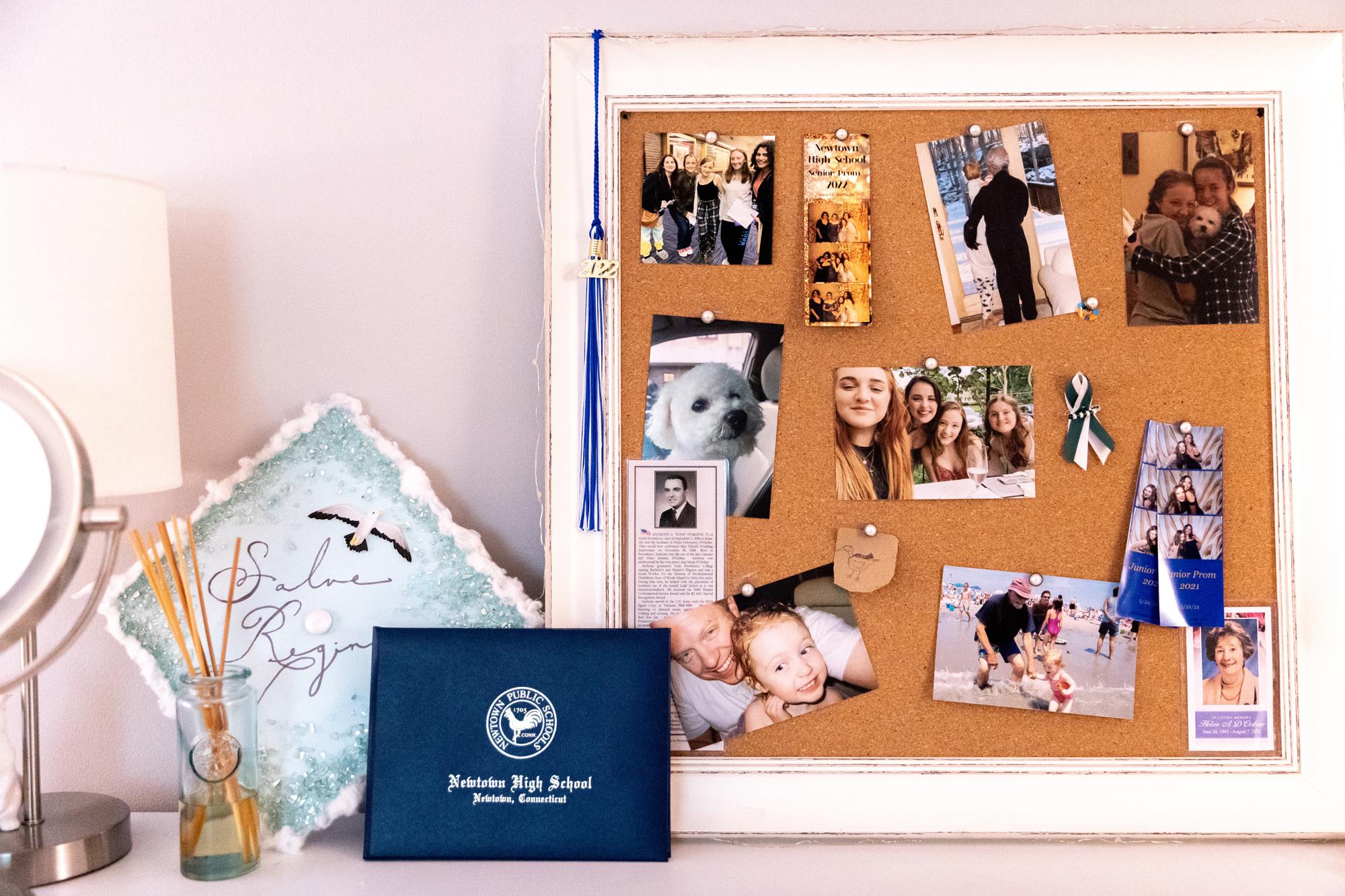 Liv Doscher's graduation cap and high school diploma rest on her dresser, Tuesday, Aug. 16, 2022, in Sandy Hook, Conn. Doscher was in third grade during the Sandy Hook shooting nearly a decade ago. (AP Photo/Julia Nikhinson)