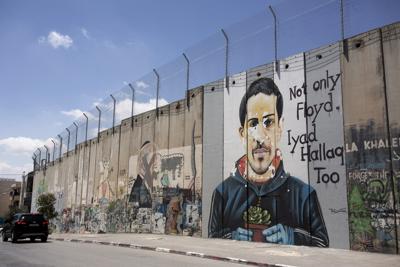 Un mural con la imagen de Eyad Hallaq, un palestino autista muerto a tiros por la policía israelí en Jerusalén el año pasado, es visto en la controversial barrera de separación en Belén, Cisjordania, el 9 de abril del 2021. Fiscales en Israel imputaron el jueves, 17 de junio,  a un policía fronterizo con un cargo de homicidio negligente por la muerte a tiros de Hallaq. (AP Foto / Maya Alleruzzo)