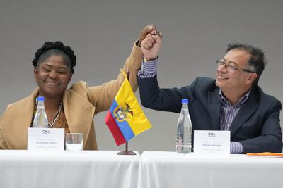 El presidente electo de Colombia, Gustavo Petro, a la derecha, y su compañera de fórmula, Francia Márquez, se dan la mano durante una ceremonia que certifica su victoria electoral, en Bogotá, Colombia, el jueves 23 de junio de 2022. (Foto AP/Fernando Vergara)