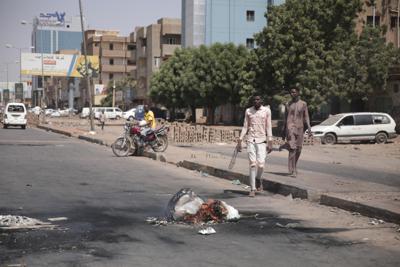 Gente caminando por una calle en Jartum, Sudán, dos días después de un golpe militar el miércoles 27 de octubre de 2021. El golpe amenazaba con descarrilar la frágil transición del país a la democracia. (AP Foto/Marwan Ali)