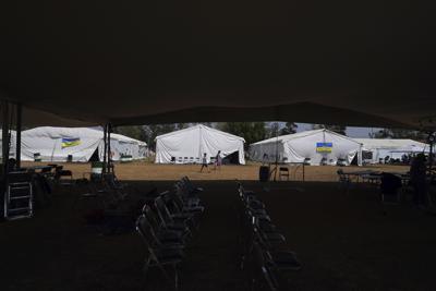 Una madre ucraniana y su hijo caminan de la mano dentro de un campo de refugiados en la delegación de Iztapalapa en la Ciudad de México, el martes 24 de mayo de 2022. La Ciudad de México cerrará el campamento que ha acogido a cientos de refugiados ucranianos durante el último mes. Ahora que un programa estadounidense que investiga a los refugiados y luego les permite volar a los Estados Unidos está operativo, las autoridades dicen que el campamento ya no es necesario. (AP Foto/Marco Ugarte)