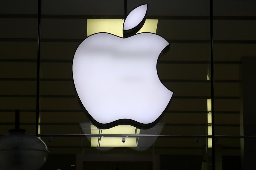 FILE - The logo of Apple is illuminated at a store in the city center in Munich, Germany, Wednesday, Dec. 16, 2020. Apple’s profit slipped during the past quarter of 2022, but the world’s largest technology company fared better than many of its peers. (AP Photo/Matthias Schrader, File)