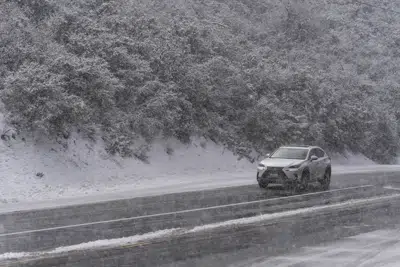 Un automovilista conduce sobre una carretera nevada en el Bosque Nacional Angeles cerca de La Canada Flintridge, California, el jueves 23 de febrero de 2023. (AP Foto/Jae C. Hong)