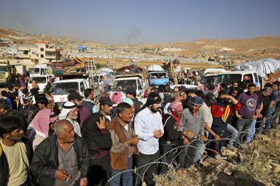 ARCHIVO - En esta fotografía de archivo del 28 de junio de 2018, refugiados sirios se reúnen para cruzar hacia Siria desde el poblado de Arsal, en el este de Líbano. (AP Foto/Bilal Hussein, archivo)