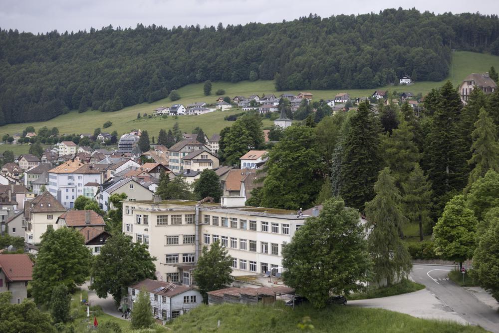 This Wednesday, June 23, 2021 photo shows an abandoned music box factory, foreground, in Sainte-Croix, Switzerland, where Lola Montemaggi stayed after the April abduction of her 8-year-old daughter in France. A group of men inspired by QAnon-style conspiracy theories are accused of kidnapping the girl to return her to Montemaggi, who had lost custody. (AP Photo/Jean-Francois Badias)