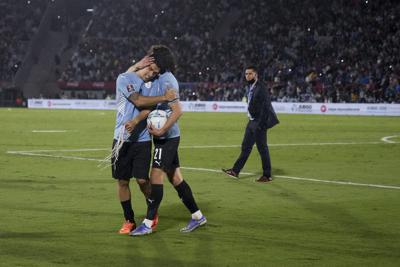 Los uruguayos Luis Suárez (izquierda) y Edinson Cavani se abrazan tras la victoria 1-0 ante Perú por las eliminatorias del Mundial, el jueves 24 de marzo, en Montevideo. (AP Foto/Matilde Campodónico, Pool)