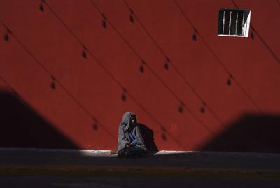 Una mujer indígena permanece sentada en una acera en Izúcar de Matamoros, en el estado mexicano de Puebla, el miércoles 29 de junio de 2022. (AP Foto/Marco Ugarte)