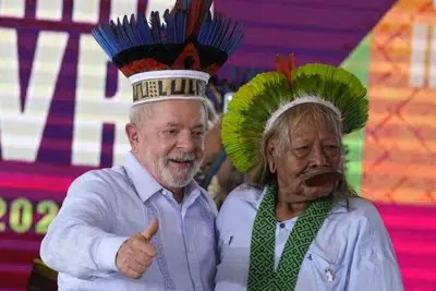 El presidente brasileño Luiz Inácio Lula da Silva enseña el pulgar tras recibir un sombrero tradicional indígena del jefe Caiapo, Raoni Metuktire, durante la clausura de un evento en Brasilia, el viernes 28 de abril de 2023. (AP Foto/Eraldo Peres)