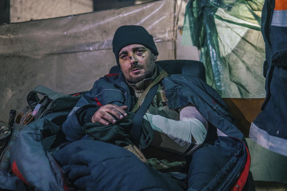 In this photo provided by Azov Special Forces Regiment of the Ukrainian National Guard Press Office, an Azov Special Forces Regiment's serviceman, injured during fighting against Russian forces, poses for a photographer inside the Azovstal steel plant in Mariupol, Ukraine, Tuesday, May 10, 2022. (Dmytro 'Orest' Kozatskyi/Azov Special Forces Regiment of the Ukrainian National Guard Press Office via AP)