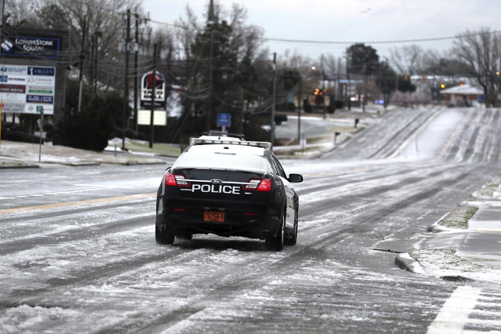 Un oficial de policía de la ciudad de Swansboro patrulla la autopista 124 cubierta de hielo después de que una tormenta de invierno azotara Carolina del Norte en Swansboro, NC, el sábado 22 de enero de 2022. Una capa de hielo y un manto de nieve han cubierto las áreas costeras que se extienden desde Carolina del Sur hasta Virginia.  El sistema de clima invernal que ingresó a la región el viernes trajo temperaturas más frías y precipitaciones que no se ven con frecuencia en la región.  (Foto AP/Tom Copeland)