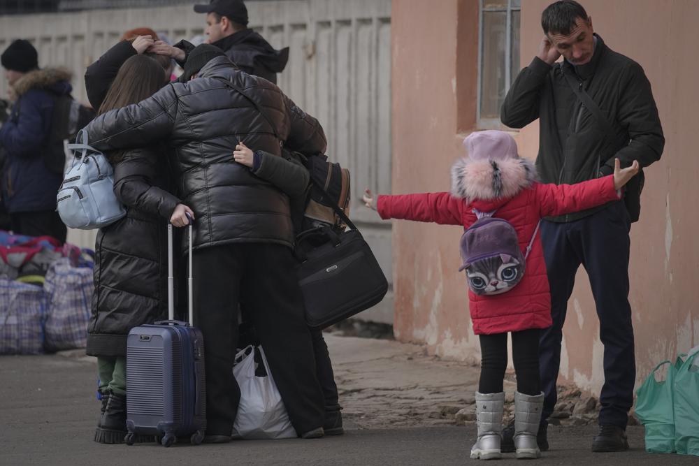 People hug while waiting for a Kiev bound train in Kostiantynivka, the Donetsk region, eastern Ukraine, Thursday, Feb. 24, 2022. (AP Photo/Vadim Ghirda)