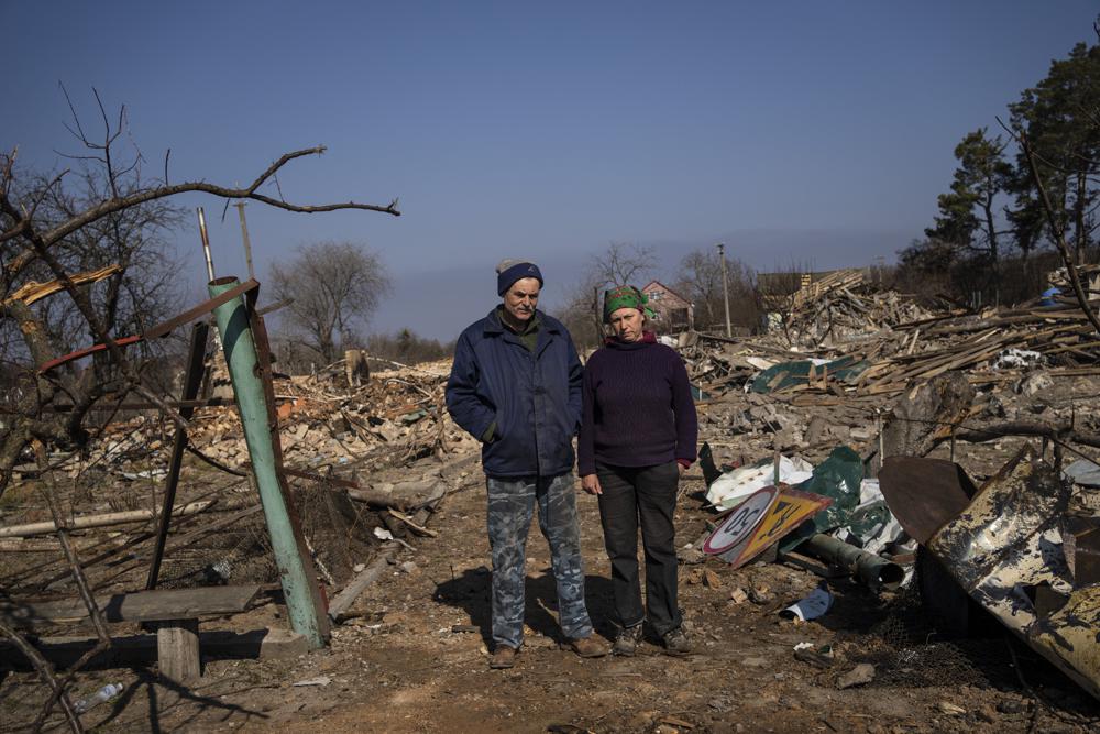 Farmer Valerie Puzakovi, 56, left, poses for a picture with his wife Svitalna, a few block from their home in Yasnogorodk, a rural town where the Ukrainian army stopped the advance of the Russian army, outskirts of Kyiv, Ukraine, Friday, March 25, 2022. (AP Photo/ (AP Photo/Rodrigo Abd)