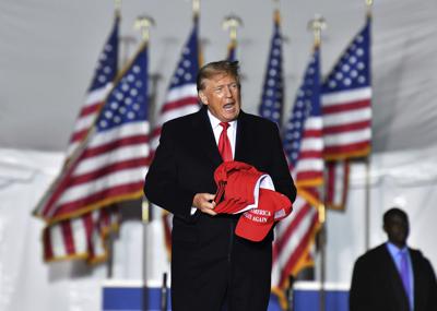 Former President Donald Trump enters the stage during a rally for Georgia GOP candidates at Banks County Dragway in Commerce, Ga., Saturday, March 26, 2022. (Hyosub Shin/Atlanta Journal-Constitution via AP)