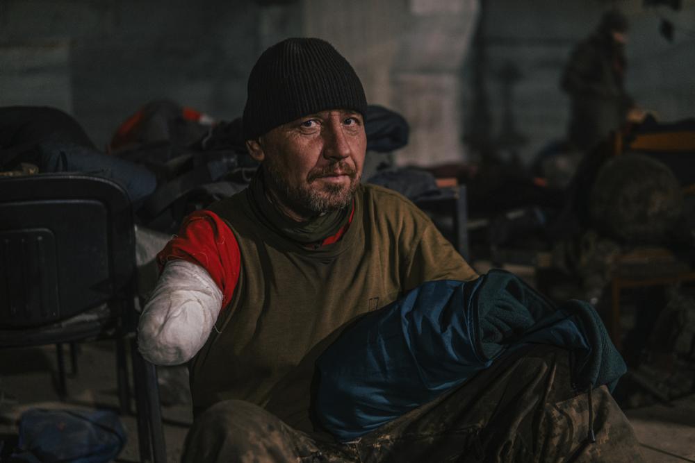 In this photo provided by Azov Special Forces Regiment of the Ukrainian National Guard Press Office, an Azov Special Forces Regiment's serviceman, injured during fighting against Russian forces, poses for a photographer inside the Azovstal steel plant in Mariupol, Ukraine, Tuesday, May 10, 2022. (Dmytro 'Orest' Kozatskyi/Azov Special Forces Regiment of the Ukrainian National Guard Press Office via AP)