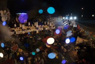 Cruces con los nombres de las víctimas de la masacre de la semana pasada en la Escuela Primaria Robb son vistas a través de un globo en un memorial en las afueras del edificio en Uvalde, Texas, el 1 de junio del 2022.  (AP Foto/Jae C. Hong)