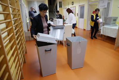 Una funcionaria electoral comprueba una urna de votación antes de sellarla en un centro electoral en Nagykanizsa, Hungría, el domingo 3 de de abril de 2022, antes de las elecciones generales y de un referendo nacional sobre una ley de protección de la infancia. (Gyorgy Varga/MTI via AP)