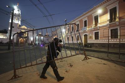 Un policía remueve una barricada durante las protestas antigubernamentales convocadas principalmente por organizaciones indígenas, en Quito, Ecuador, el jueves 16 de junio de 2022. (AP Foto/Dolores Ochoa)