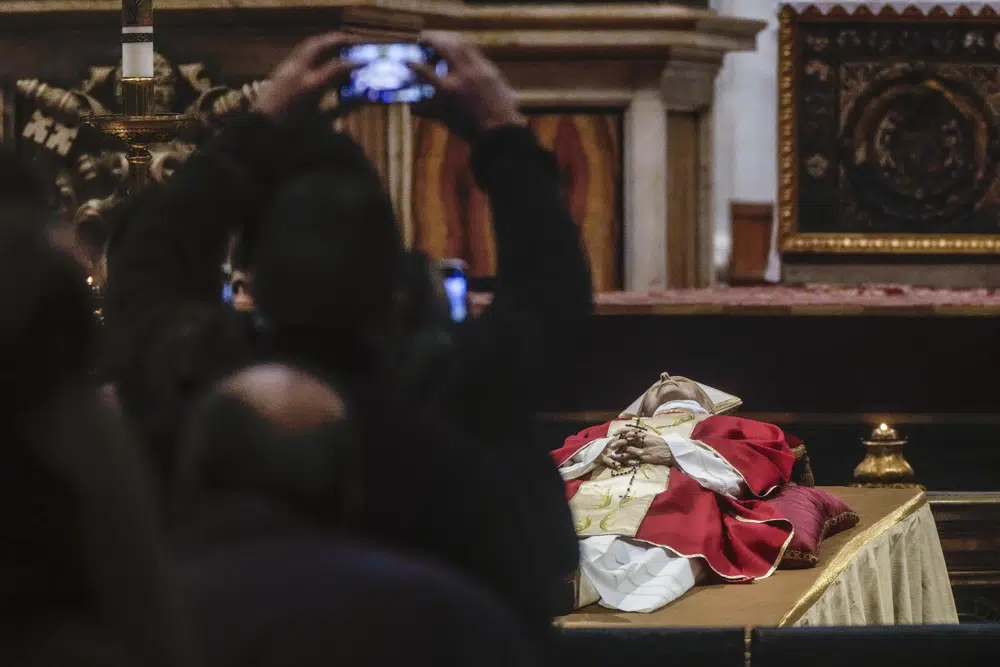 People line up to pay their respect to Pope Emeritus Benedict XVI lying out in state inside St. Peter's Basilica at The Vatican, Monday, Jan. 2, 2023. Benedict XVI, the German theologian who will be remembered as the first pope in 600 years to resign, has died, the Vatican announced Saturday. He was 95. (AP Photo/Gregorio Borgia)