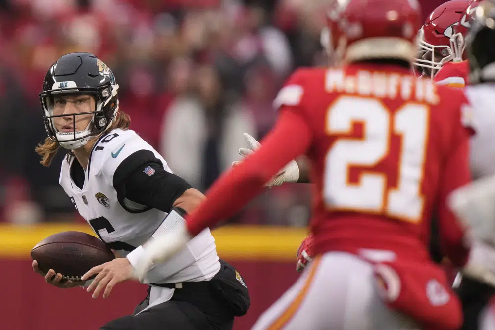 Jacksonville Jaguars quarterback Trevor Lawrence (16) runs out of the pocket against the Kansas City Chiefs during the first half of an NFL divisional round playoff football game, Saturday, Jan. 21, 2023, in Kansas City, Mo. (AP Photo/Charlie Riedel)