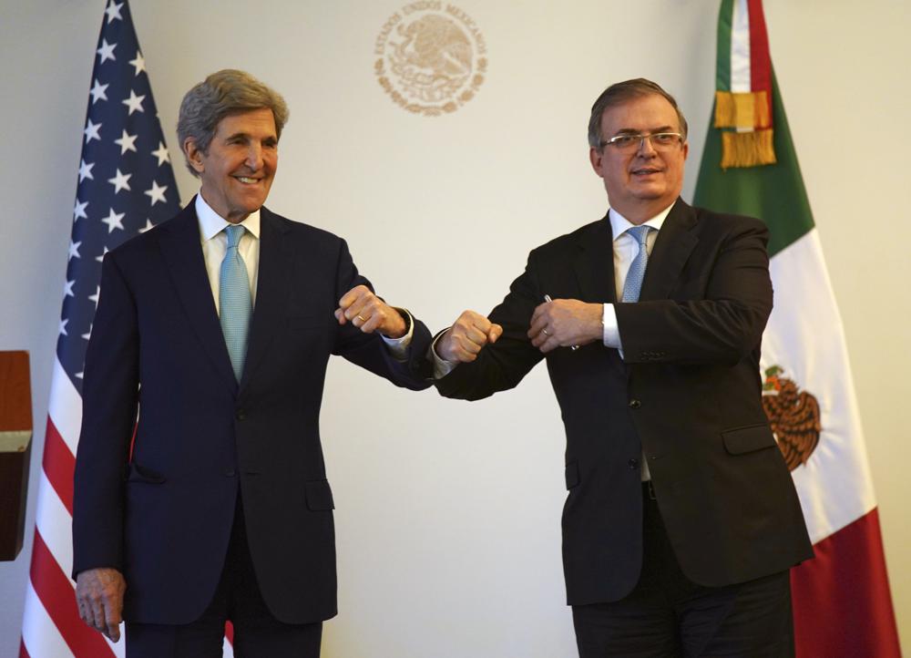 U.S. climate envoy John Kerry, left, bumps elbows with Mexican Foreign Minister Marcelo Ebrard during a photo opportunity on the sidelines of a meeting in Mexico City, Wednesday, Feb. 9, 2022.  Kerry arrived for talks amid high tensions over Mexico’s plan to favor its state-owned electricity company and limit private and foreign firms that have invested in renewable energy. (AP Photo/Fernando Llano)