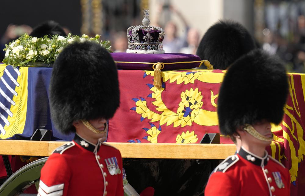 Grenadier Guards flank the coffin of Queen Elizabeth II during a procession from Buckingham Palace to Westminster Hall in London, Wednesday, Sept. 14, 2022. The Queen will lie in state in Westminster Hall for four full days before her funeral on Monday Sept. 19. (AP Photo/Kirsty Wigglesworth)
