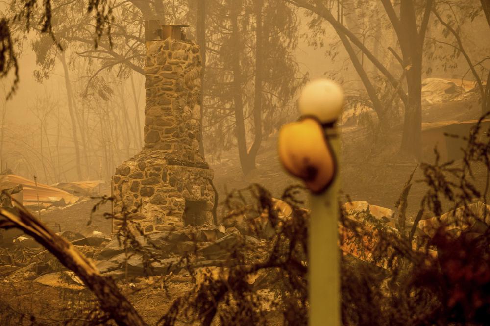 A chimney stands at a destroyed building as the McKinney Fire burns in Klamath National Forest, Calif., on Sunday, July 31, 2022. (AP Photo/Noah Berger)