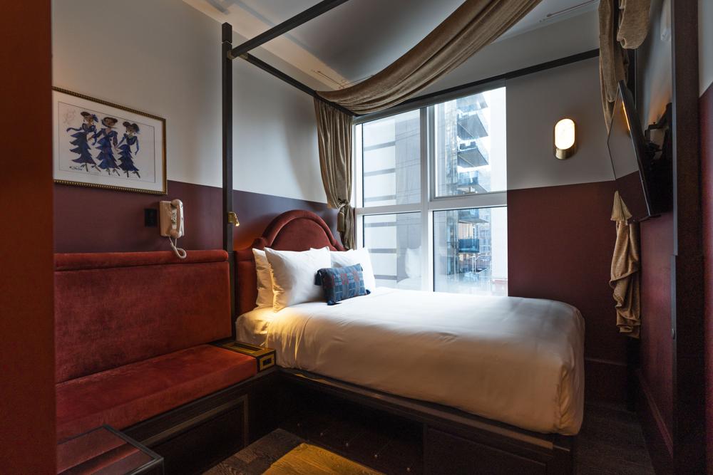 A hotel room is displayed at the new Civilian hotel in New York's Theater District, Monday, Nov. 15, 2021. The 203-room hotel is packed with hundreds of pieces of Broadway art, including sketches, set models, costume pieces, photographs and artifacts that show theater past and present.  (AP Photo/Richard Drew)