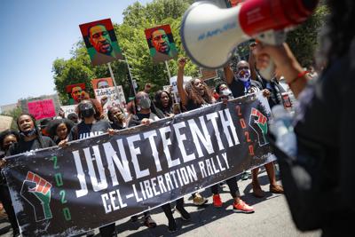 ARCHIVO - En esta fotografía de archivo del 19 de junio de 2020, manifestantes participan en una marcha tras un mitin por el Juneteenth _fecha en que se conmemora la emancipación de los esclavos_ en el Museo de Brooklyn, en ese distrito de la ciudad de Nueva York. (AP Foto/John Minchillo, archivo)