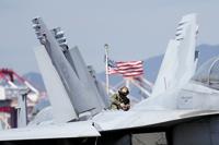 U.S. soldier checks the F/A-18 Super Hornet fighter jet on the deck of the nuclear-powered aircraft carrier USS Ronald Reagan in Busan, South Korea, Friday, Sept. 23, 2022. The nuclear-powered aircraft carrier USS Ronald Reagan arrived in the South Korean port of Busan on Friday ahead of the two countries' joint military exercise that aims to show their strength against growing North Korean threats. (AP Photo/Lee Jin-man)