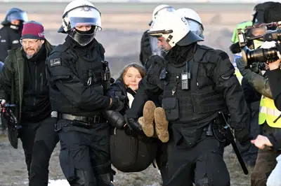 La policía se lleva por la fuerza a la activista climática sueca Greta Thunberg de la entrada a la mina abierta de lignito Garzweiler II después de expulsar a manifestantes de Luetzerath, Alemania, martes 17 de enero de 2023.(Federico Gambarini/dpa via AP)