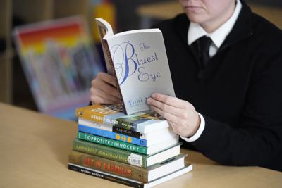 ARCHIVO - Amanda Darrow, directora de programas para la juventud, la familia y la educación en el Utah Pride Center, posa con libros que incluyen "The Bluest Eye" de Toni Morrison, que han sido objeto de quejas de padres en Salt Lake City, el 16 de diciembre de 2021. La ola de prohibiciones de libros en EE.UU. ha alcanzado un nivel no visto en décadas. (Foto AP/Rick Bowmer, archivo)
