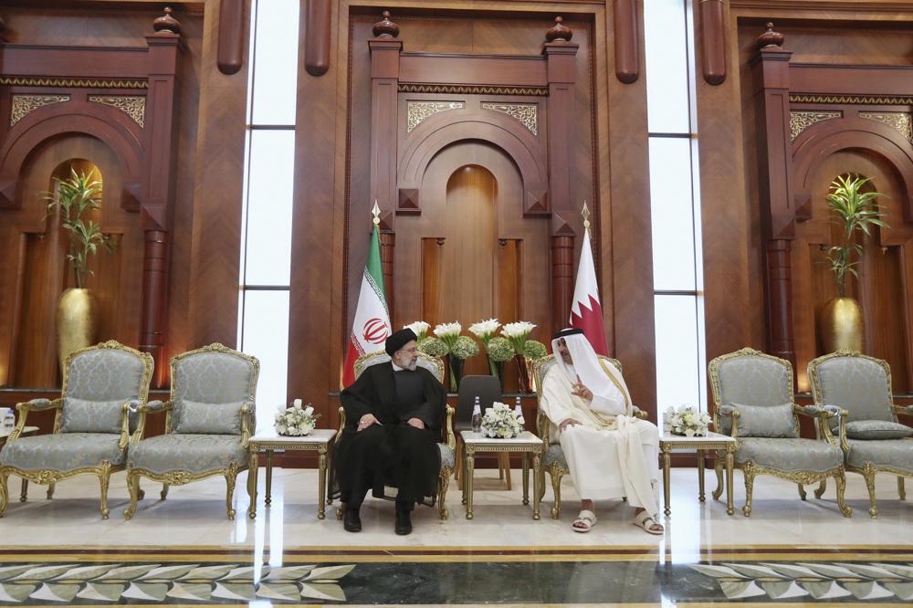 In this photo released by the official website of the office of the Iranian Presidency, President Ebrahim Raisi, left, listens to Qatari Emir Tamim bin Hamad Al Thani, in Doha, Qatar, Monday, Feb. 21, 2022. Iran's president has arrived in Qatar for a summit of gas exporting countries, the state-run news outlet reported Monday. (Iranian Presidency Office via AP)