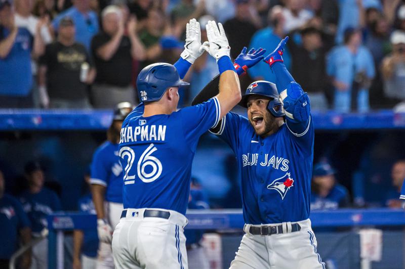 Toronto Blue Jays' George Springer (4) celebrates with Matt Chapman (26) after hitting a grand slam during the sixth inning of a baseball game against the St. Louis Cardinals, Tuesday, July 26, 2022 in Toronto. (Christopher Katsarov/The Canadian Press via AP)