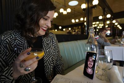 Erin Tridle en videoconferencia con su novio Jordan Commarrieu, quien vive en París, desde su restaurante francés favorito "Petit Trois" en Los Ángeles, el viernes 5 de noviembre de 2021. (AP Foto/Damian Dovarganes)
