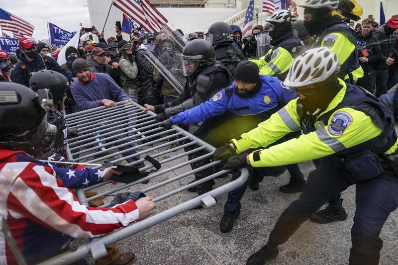 FILE - In this Jan. 6, 2021, file photo violent insurrectionists loyal to President Donald Trump hold on to a police barrier at the Capitol in Washington.  A New Jersey gym owner on Friday became the first person to plead guilty to assaulting a law enforcement officer during the Jan. 6 riot at the U.S. Capitol.  (AP Photo/John Minchillo, File)