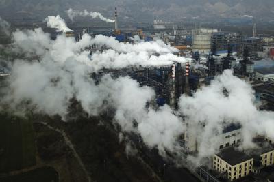 ARCHIVO - Humo y vapor se elevan desde una planta de procesamiento de carbón el 28 de noviembre de 2019 en Hejin, en la provincia central china de Shanxi. (AP Foto/Sam McNeil, Archivo)