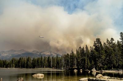 Un avión cisterna vuela sobre el Lago Wrights mientras combate el incendio Caldor en el Bosque Nacional de Eldorado, el miércoles 1 de septiembre de 2021. (AP Foto/Noah Berger)