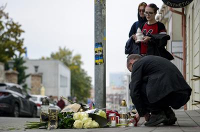 Unas personas dejan flores y encienden velas el jueves 13 de octubre de 2022 en el sitio donde se perpetro un tiroteo en Bratislava, Eslovaquia. (Pavol Zachar/TASR vía AP)