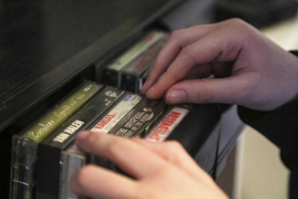 Asher Wilcox-Broekemeier, 13, pulls an a album by The Offspring from his cassette tape collection, Monday, March 27, 2023, in Sioux Falls, S.D. His favorite bands also include Green Day and Blink-182. (AP Photo/Erin Woodiel)