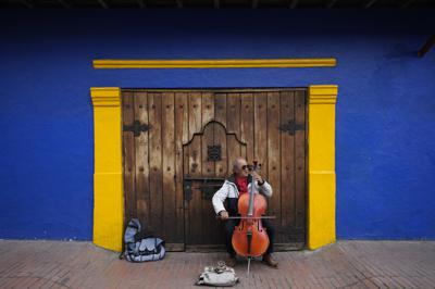 Fabio Guarin, de 76 años, toca un violonchelo para recibir propinas que dice que usa para comprar sus comidas en el barrio La Candelaria de Bogotá, Colombia, el 4 de agosto de 2022, años después de tocar en una banda amateur conocida como "toque", contratada en bares y eventos privados. El 13 de octubre de 2022, el FMI informó que la economía de América Latina mejoró más allá de las expectativas en 2022 y se desacelerará en 2023. (Foto AP/Fernando Vergara, Archivo)