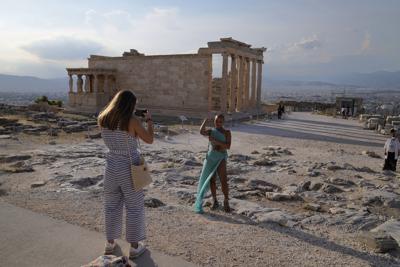 En esta imagen de archivo, tomada el 8 de junio de 2021, una turista toma fotos delante del Partenón durante una visita para reporteros extranjeros organizada por el Ministerio de Cultura griego a la Acrópolis, en Atenas. (AP Foto/Thanassis Stavrakis, arhivo)