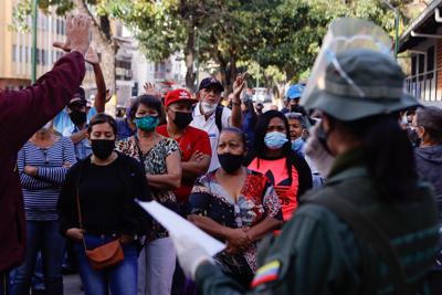 La gente discute con los funcionarios electorales en un colegio electoral que no abrió un tiempo durante las elecciones regionales, en el barrio San Agustín de Caracas, Venezuela, el domingo 21 de noviembre de 2021. Los venezolanos acuden a las urnas para elegir gobernadores estatales y otros funcionarios locales.  (Foto AP / Jesús Vargas)