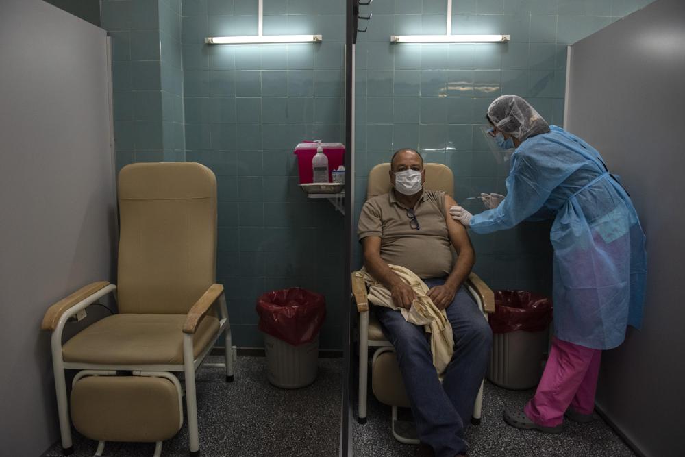 Un hombre recibe una inyección de la vacuna Sinovac para el COVID-19 en un hospital público de Montevideo, Uruguay, el viernes 14 de mayo de 2021. (AP Foto/Matilde Campodonico)