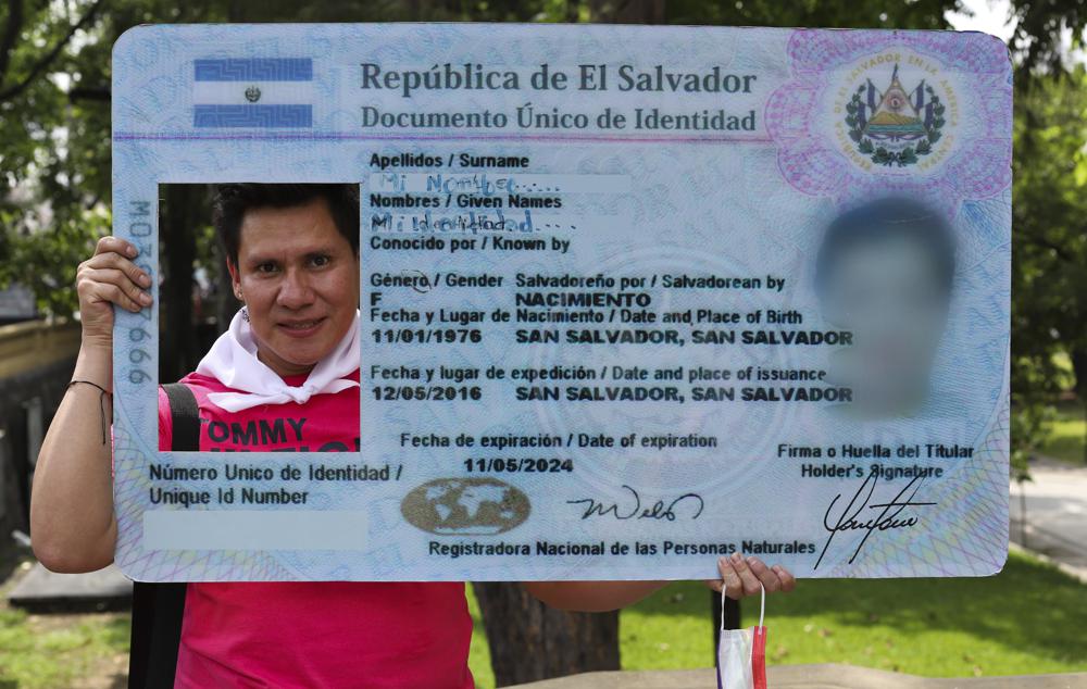 Wilson Escobar posa para una foto con un recorte gigante de cédula de identidad antes del inicio de un evento que marca el Día Internacional contra la Homofobia en San Salvador, El Salvador, el lunes 17 de mayo de 2021. Más de 600 personas de la comunidad LGBTQ han sido asesinadas desde 1993 en El Salvador, un país de sólo 6,5 millones de habitantes, según la ONG COMCAVIS TRANS. (Foto AP/Salvador Meléndez)