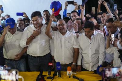 El candidato opositor Sergio Garrido _al centro, con una gorra en la mano_ festeja luego de que su contrincante oficialista Jorge Arreaza reconoció en redes sociales su derrota en los comicios para elegir gobernador del estado de Barinas, el domingo 9 de enero de 2022, en Venezuela. Freddy Superlano, segundo de izquierda a derecha, fue descalificado retroactivamente en las elecciones de noviembre. (AP Foto/Matías Delacroix)